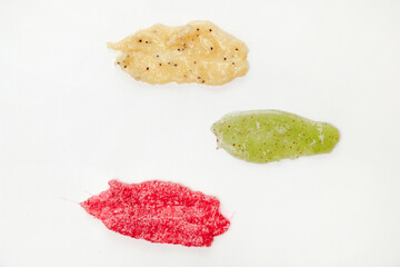 Three Colorous Cosmetics Scrub Smudges Samples on White background. Top view