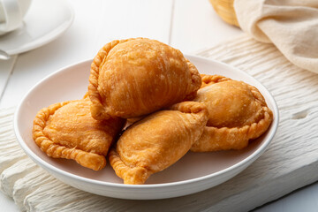 curry puff in white plate,fried curry dumpling (with meat or vegetable snuffing)