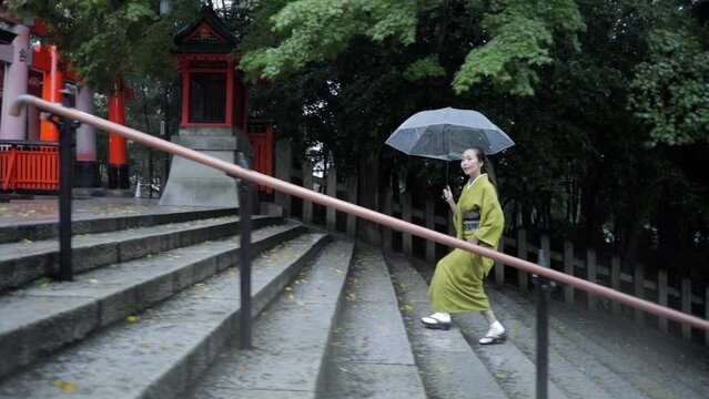 Elegant Japanese woman walking in the rain at dawn