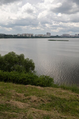 Naklejka premium Landscape, view of the lake and the shore, green trees and water surface