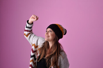mulher comemorando vitória com roupa de inverno e touca de frio 