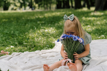 portrait happy little girl resting in the park smelling flowers carefree childhood summer day outdoor recreation