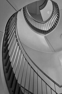 Black and white photo. View of the spiral staircase in the house.
