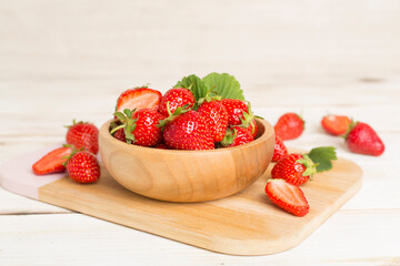 Fresh strawberries in bowl on wooden table