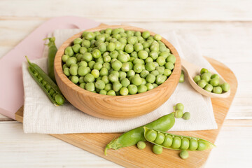 Composition with fresh green peas on wooden table