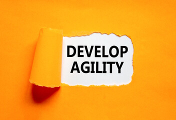 Develop agility symbol. Concept words Develop agility on beautiful white paper on a beautiful orange background. Business, support and develop agility concept. Copy space.