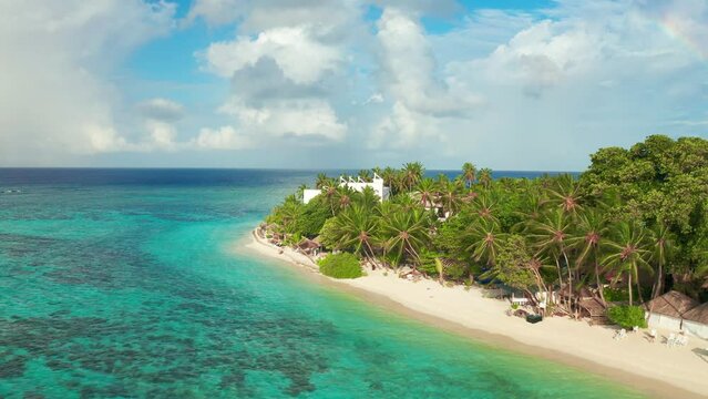 Tropical beach with blue water and palm trees, Thinadhoo island, Vaavu Atoll, Maldives. Aerial drone view 4K.
