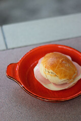 Homemade bun, baloney and cheese sandwich, served in a garden. Selective focus.
