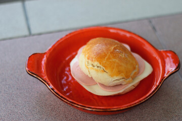 Homemade bun, baloney and cheese sandwich, served in a garden. Selective focus.