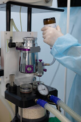 An anesthesiologist pouring anesthesia into a gas machine in the operating room The...
