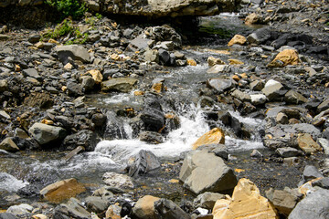 Water flowing over river rocks near mountains in Nathia Gali, Abbottabad, Pakistan.