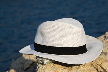 White hat on the rocks near the sea