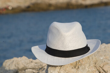 White hat on the rocks near the sea
