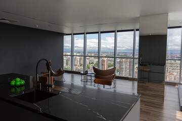 dark minimalistic design of a trendy chic studio apartment with panoramic windows on a high floor overlooking the city