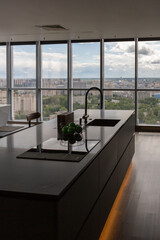 dark minimalistic design of a trendy chic studio apartment with panoramic windows on a high floor overlooking the city