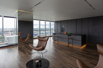 dark minimalistic design of a trendy chic studio apartment with panoramic windows on a high floor...