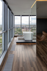 dark minimalistic design of a trendy chic studio apartment with panoramic windows on a high floor overlooking the city