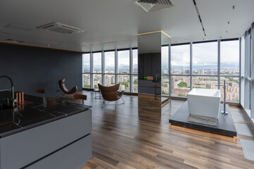 dark minimalistic design of a trendy chic studio apartment with panoramic windows on a high floor...
