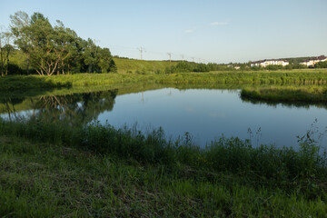 Fototapeta premium Landscape, view of the lake and the shore, green trees and water surface
