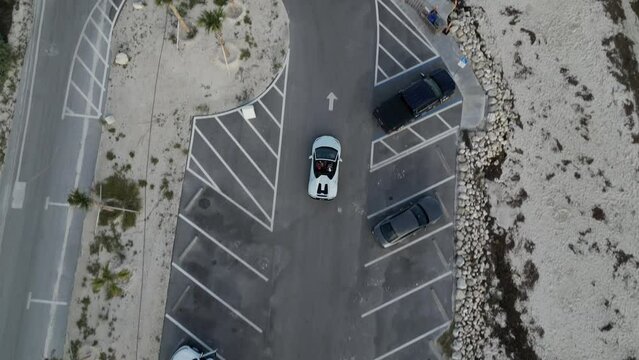 Aerial video view of sports car driving along the coast