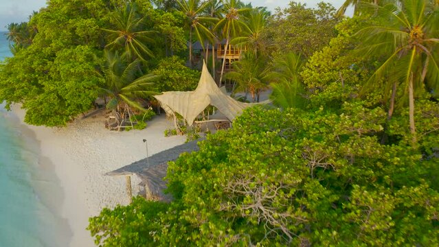 Wonderful Maldivian boat Dhoni on tropical blue sea, taking tourist to a sunset cruise. Aerial drone view 4K.
