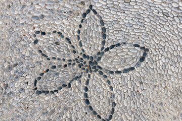 Stone street paving background from old town Rhodes in greece with black stones in flower pattern
