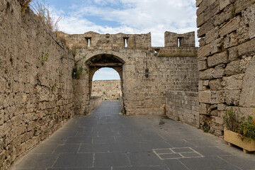 Fototapeta na wymiar Empty street in old town in Rhodes, Greece surrounded by fortification stone walls