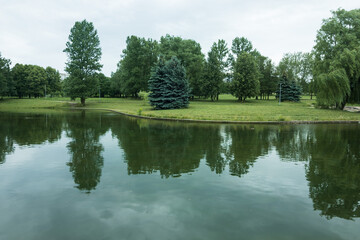 Fototapeta na wymiar Landscape, view of the lake and the shore, green trees and water surface