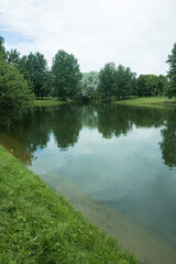 Obraz premium Landscape, view of the lake and the shore, green trees and water surface