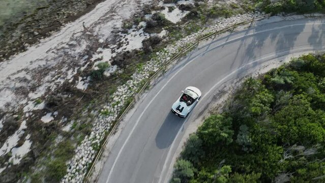 Aerial video view of sports car driving along the coast
