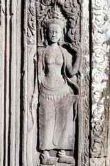 A sculptural image of a woman on the wall of an ancient temple in Cambodia, a stone bas-relief.