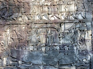 Ancient bas-reliefs illustrating historical and mythical subjects on the walls of the Khmer Bayon Temple.
