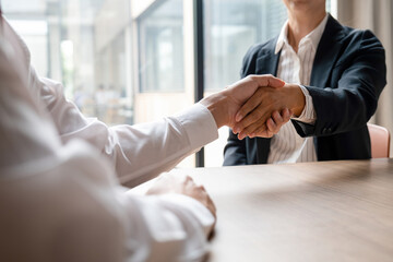 Man shaking hands with interviewer for successful negotiations.