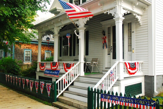 A historic house in New England is decorated with American flags on the Fourth of July Independence day