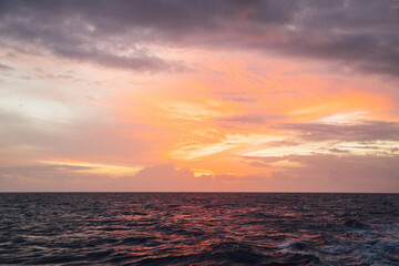 Beautiful pastel pink and orange sunset over the ocean near the Na Pali coastline on the island of Kauai, Hawaii
