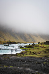 Somewhere in iceland - little river with waterfall in a moody and cloudy landscape in summer