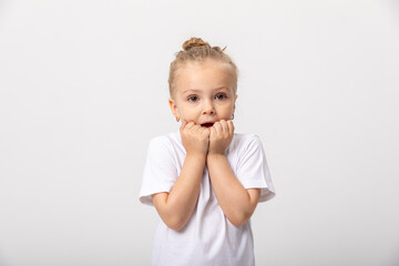 Cute scared kid girl wearing casual clothes white t-shirt standing isolated on white background, cover mouth and emotion face concept