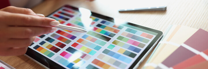 Woman working with color palette and tablet in office