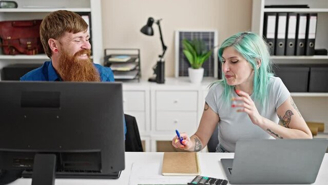 Man and woman business workers using laptop and computer stand up shake hands at office