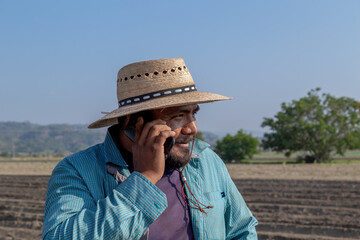 Agricultural Technology: Connected Farmer Making a Phone Call in the Crop Field