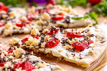 Fototapeta na wymiar Tart with strawberries and whipped cream decorated with mint leaves