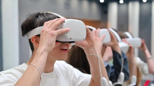 Group of four excited teens putting on VR headset and starts playing games on a VR arena. The team leader giving commands. Slow motion