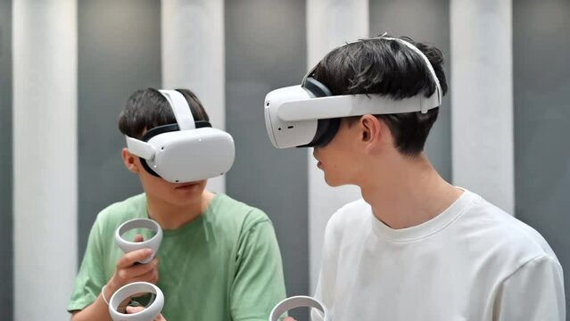 Group of two teens with VR headset and controllers playing games in a team. Tactfully walking through the VR arena. Slow motion