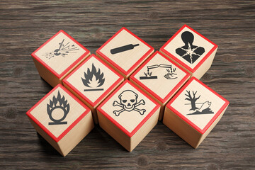 Wooden blocks showing different symbols of chemical hazard warnings on wood table. Illustration of the concept of toxic substances and occupational health - obrazy, fototapety, plakaty