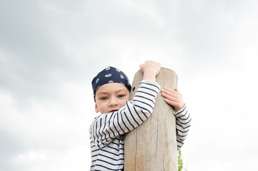 Little boy is playing as a pirate on the wooden playground.