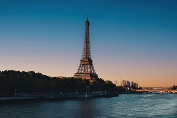 Fototapeta na wymiar The Eiffel Tower across the Seine River in Paris, France. Sunset. Sunny day in the late afternoon