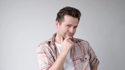 man is deep in thought, scratching his chin while trying to choose something