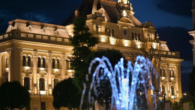 View of the Oradea City Hall facade at night in Romania. Illumination, fountain on the foreground