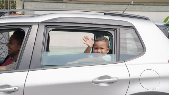 Family goes on vacation and little boy waving into camera
