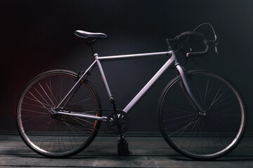 Fototapeta na wymiar gray street sports bike in a dark room illuminated by red light